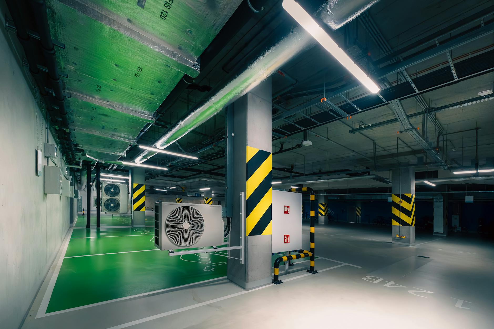 Podziemny parking z jednostkami klimatyzacji w zielonym oświetleniu