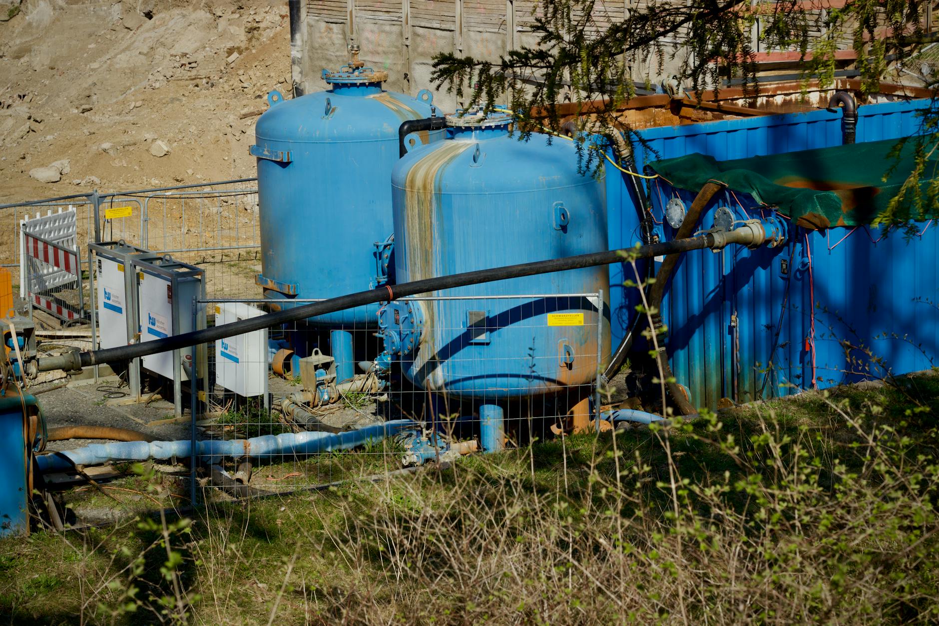 Zewnętrzna instalacja filtracji wody technologicznej z dużymi niebieskimi zbiorn